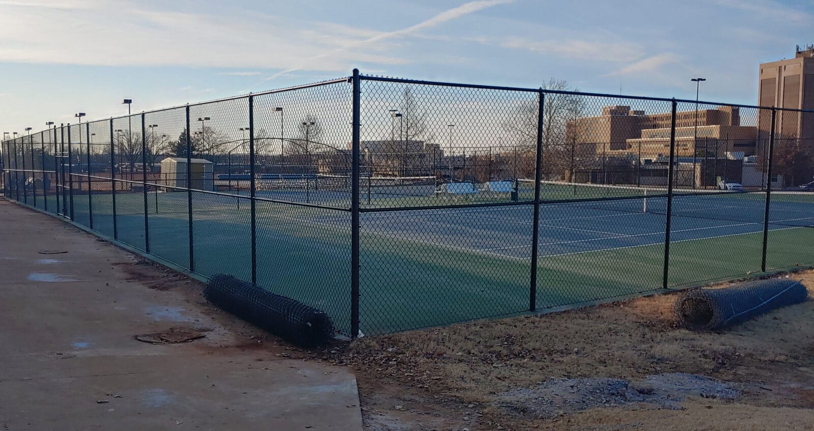 Large Metal fence surrounding tennis court